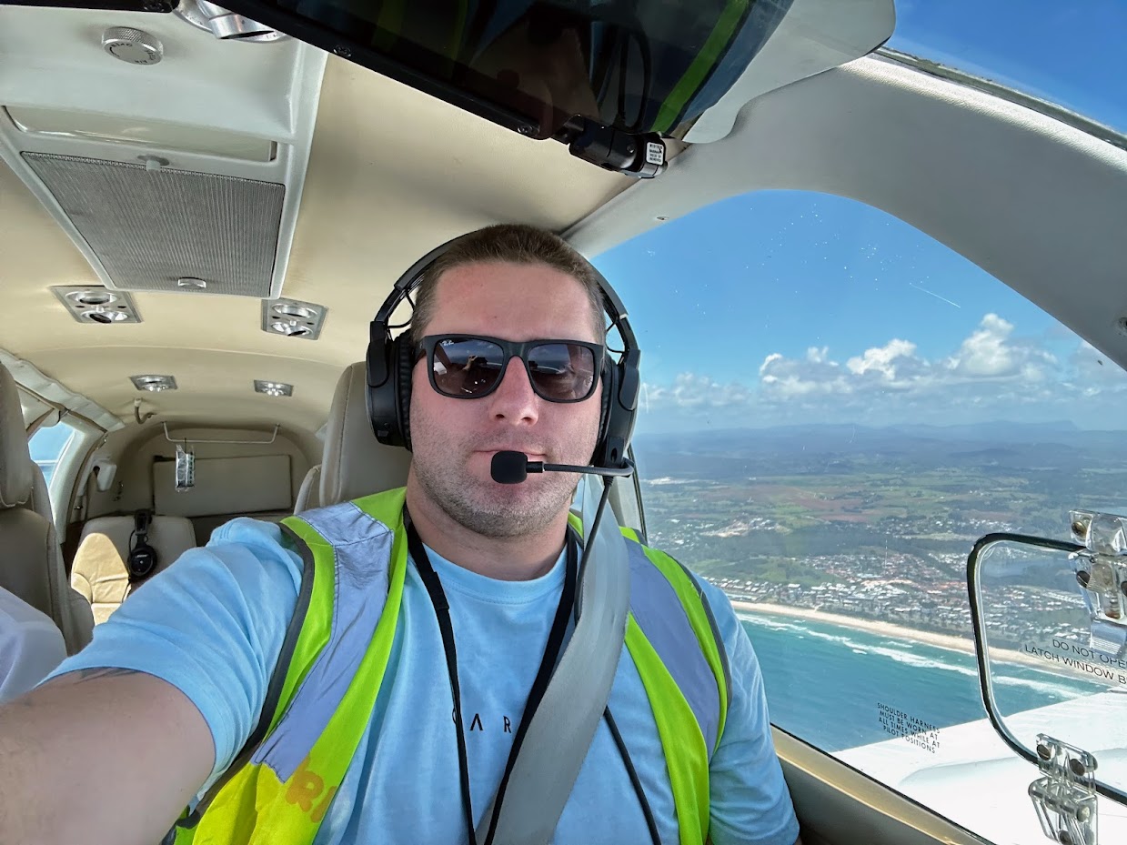 Byron flying a light plane over the coast.